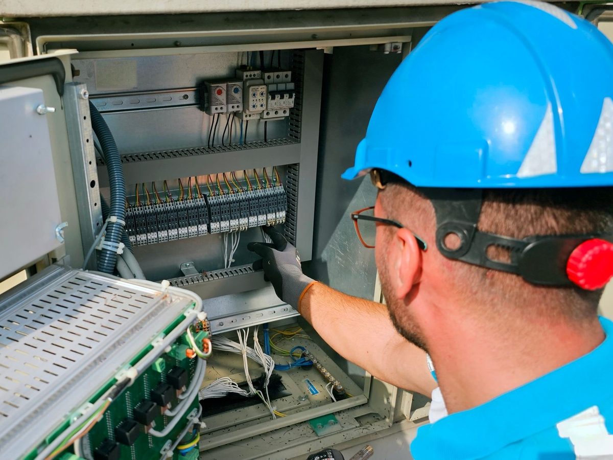 Arkansas Protection Services technician wiring a security control panel in Central Arkansas